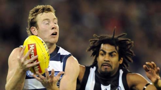Collingwood's Harry O'Brien arrives a fraction too late to prevent Geelong's Steve Johnson from taking a mark.
