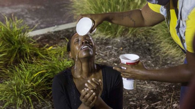 A woman is overcome by tear gas in Ferguson, Missouri, on Sunday night.