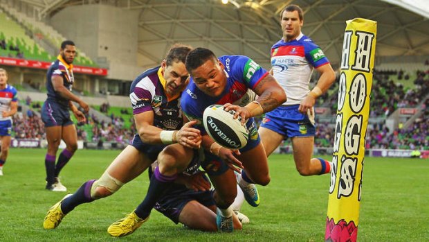 Tight fit: Billy Slater tackles the Knights' Joey Leilua.