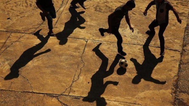 Displaced Iraqi Christians play soccer in the courtyard of Saint Joseph's church after having to flee their district in Erbil, Iraq.