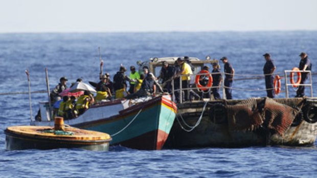Customs officials take people from a vessel intercepted just off Christmas Island on Thursday.