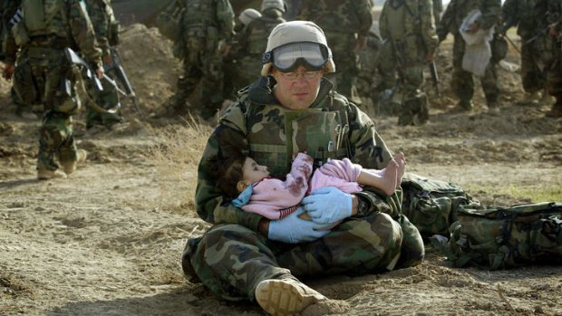 An American medic holds a child whose family was caught in the crossfire in central Iraq in 2003.