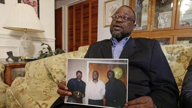 Anthony Scott holds a photo of himself, centre, and his brothers Walter (left) and Rodney, at his home near North Charleston, South Carolina. 