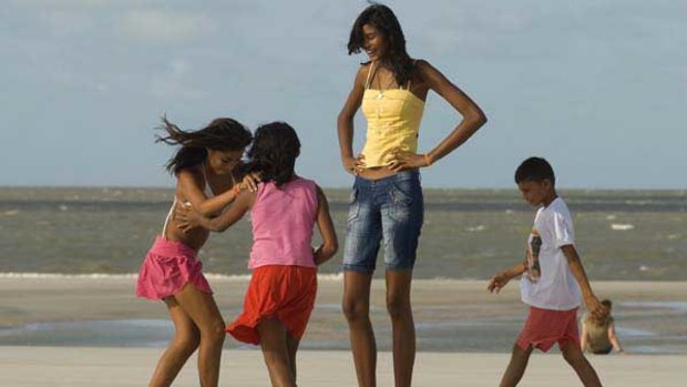 Elisany Silva, 14, who measures 2.06 metres, with her sisters and a friend on a beach win Brazil.
