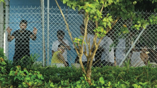 Asylum seekers behind wire on Manus Island.