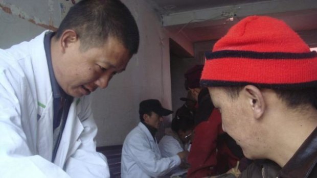 A Chinese researcher collects a blood sample from a Tibetan man participating in the DNA study published in "Nature" on Wednesday.