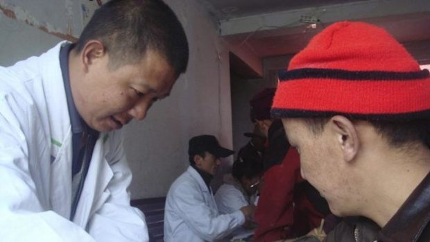 A Chinese researcher collects a blood sample from a Tibetan man participating in the DNA study published in "Nature" on Wednesday.