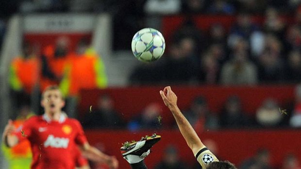 Manchester United forward Dimitar Berbatov tackles Benfica's Manuel Vitor (top).
