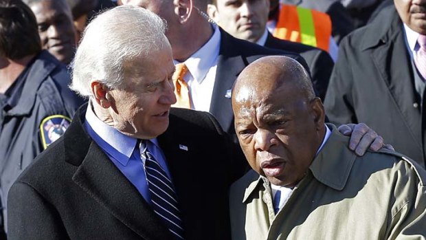 Recommitting: Joe Biden (left) and John Lewis prepare to lead marchers across Edmund Pettus Bridge to commemorate the march for voter rights in 1965.