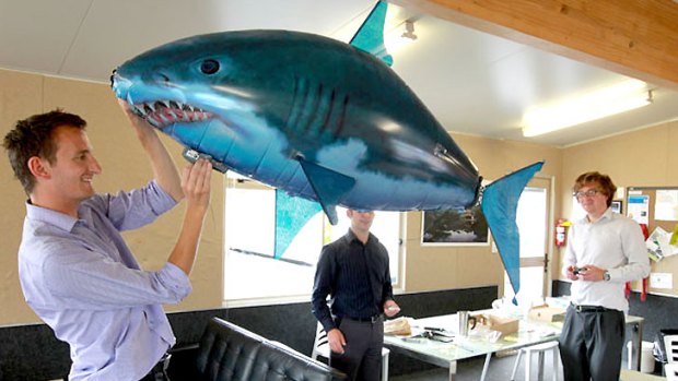 A helium-inflated shark like one reported by a jet pilot on a flightpath to Christchurch Airport is tested by Press reporters Michael Wright, left, Keith Lynch, right, and Marc Greenhill, obscured.