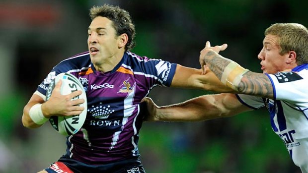 Billy Slater fends-off the Bulldogs Trent Hodkinson.