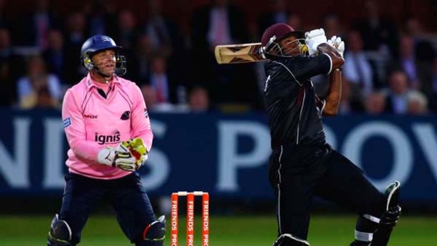 Somerset batsman Kieron Pollard hits a six watched by Middlesex wicketkeeper Adam Gilchrist.