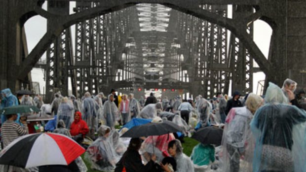 Families struggle to keep dry at Breakfast on the Bridge yesterday.