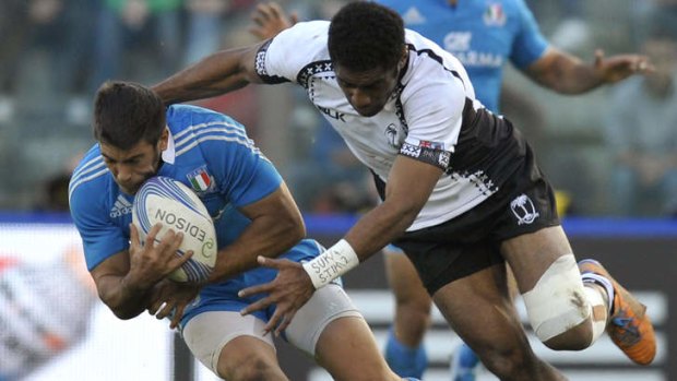 Can lay a hit: Italy's Edoardo Gori is tackled by Fiji Islands's Asaeli Tikoirotuma.