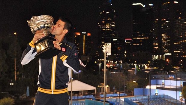 King of the night &#8230; Novak Djokovic takes a moment to mark his achievement before boarding a flight for Belgium.