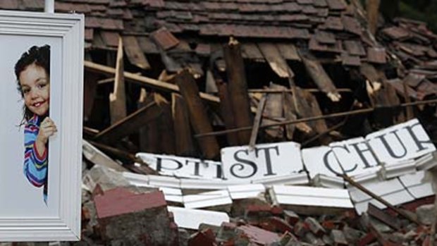 A billboard  in front of the wrecked  Baptist church in Christchurch.
