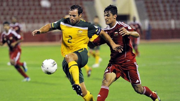Lucas Neill moves the ball upfield for the Socceroos.