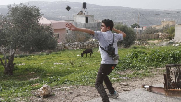 A Palestinian protester uses a slingshot to throw stones at Israeli soldiers during clashes following a protest against the near-by Jewish settlement of Qadomem, in the West Bank village of Kofr Qadom.
