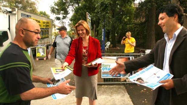 Nicole Campbell candidate for labor and Victor Dominello candidate for liberal party both handing out pamphlets outside west ryde public school.