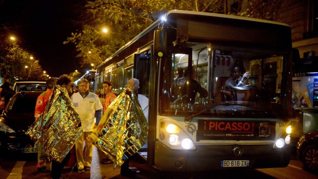 Survivors from the Bataclan Eagles of Death Metal concert, where the Australian was headed, board a bus after the attack. 