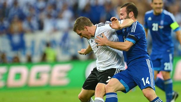 No quarter given: Greece's Dimitris Salpingidis (right) battles with Germany's Bastian Schweinsteiger.