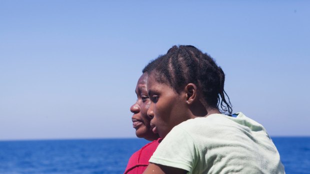 Women from Nigeria stand at the deck of the rescue vessel Golfo Azurro after being rescued by aid workers of Proactiva Open Arms off the Libyan coast on August 1.