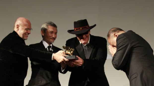 Honoured ... John Woo bows as he accepts the Golden Lion award from filmmakers (from left) Marco Mueller, Tsui Hark and Quentin Tarantino.
