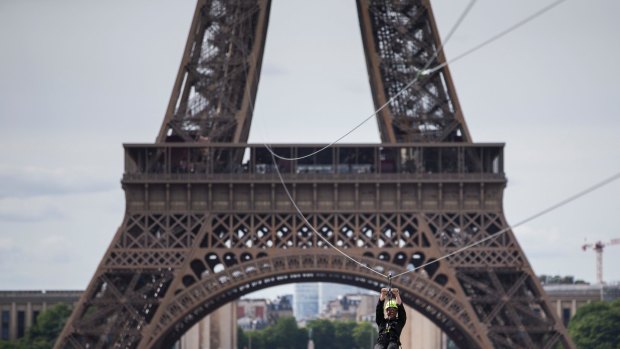 A man rides an 800-metre zip line from the second floor of the Eiffel Tower in Paris.