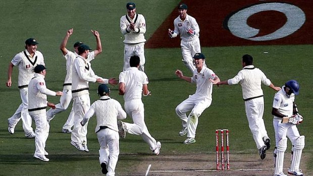 At last: Mitchell Starc runs to teammates after snaring the last wicket.