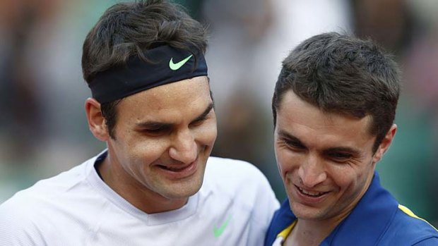 Switzerland's Roger Federer (L) embraces France's Gilles Simon at the end of their match.