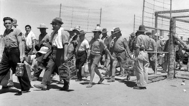 Barmera, South Australia. 1943-12-31. Italian internees pass through the compound gates carrying their personal belongings..