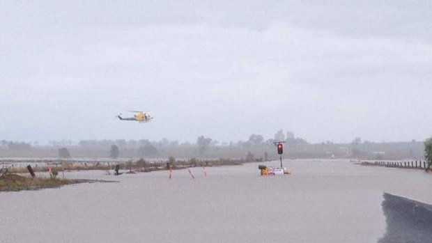 RACQ Care Flight helicopter aids in the rescue of two men and two children from rising floodwaters near Oakey on Sunday.