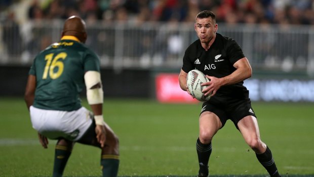 En route: Ryan Crotty of New Zealand is challenged by Bongi Mbonambi of South Africa.