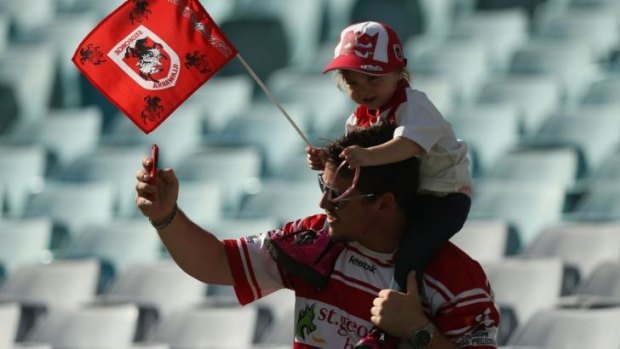 Flying the flag: Low crowds over the first round may have worried some NRL types, but these Dragons fans would have been too busy celebrating their big win over the Tigers to get antsy about the vacant seats at ANZ Stadium.
