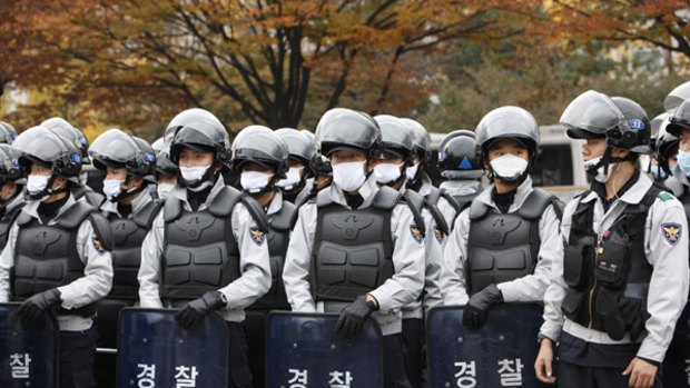 Swine flu alarm...riot police wear masks at a rally