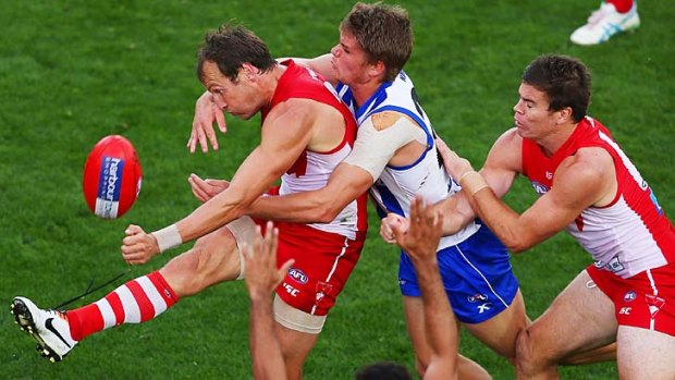 Sydney's Jude Bolton, who finished with four goals, gets his kick away when getting tackled by his opponent.