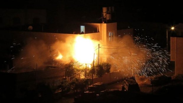 Flames are seen after a blast on the top floor of the family home of an alleged abductor in the West Bank City of Hebron.
