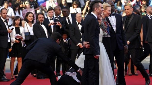 A man is arrested by security as he tries to slip under the dress of actress America Ferrera.