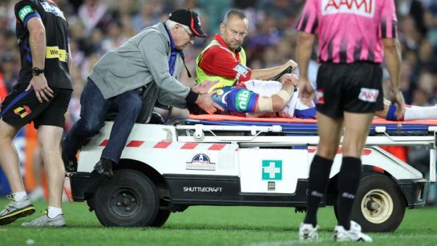 Down and out: Retiring Knights star Danny Buderus is taken from the field after colliding with Jared Waerea-Hargreaves.