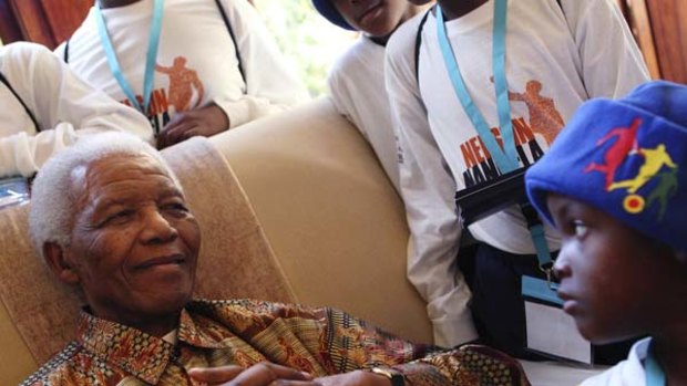 Former President Nelson Mandela greets children from Mvezo and Qunu villages, who came to wish him well ahead of his birthday, in Johannesburg.