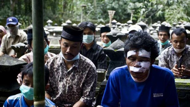 Villagers pray at the burial of a victim of the Mount Merapi eruption