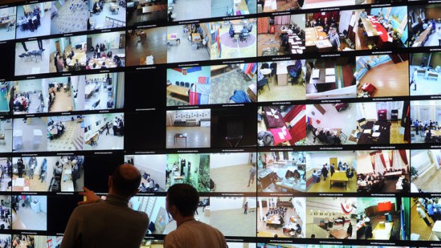 People look at the screens broadcasting views from polling stations via a network of webcams.