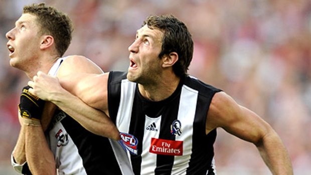 Travis Cloke, pictured battling St Kilda's Zac Dawson in the first AFL grand final for 2010, has signed a new two-year deal with the Magpies.