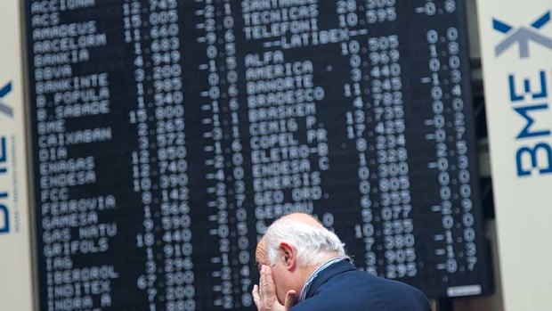 A trader gestures as he watches a trading wall at the Madrid Bourse.