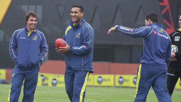 Having a ball: Newly capped Wallaby Cooper Vuna tries out a Sherrin with Nick Phipps (left) and Anthony Faingaa yesterday.