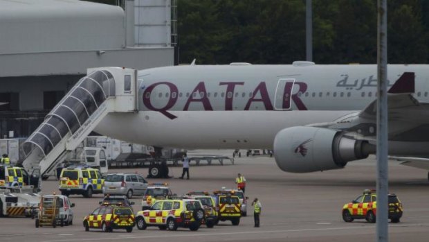 A Qatar Airways aircraft is seen surrounded by emergency vehicles at Manchester Airport.