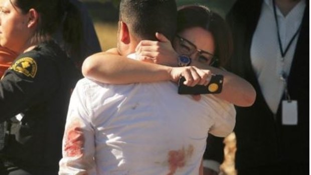 Survivors console each other at scene of the mass shooting in San Bernadino.