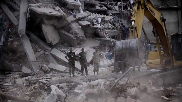 Bleak outlook: Bangladeshi soldiers stand in the rubble at the site where a building collapsed near Dhaka.