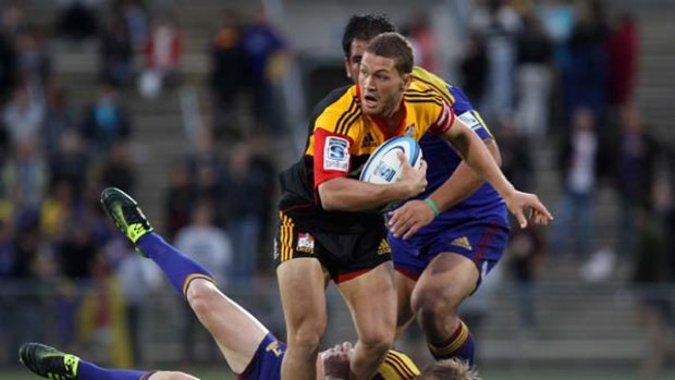 Tawera Kerr-Barlow of the Chiefs is tackled by Jimmy Cowan of the Highlanders.