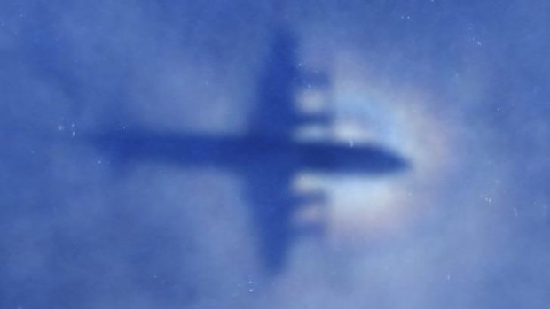 The shadow of a Royal New Zealand Air Force P-3 Orion aircraft is seen on low cloud cover while it searches for missing Malaysia Airlines Flight MH370 in the southern Indian Ocean.